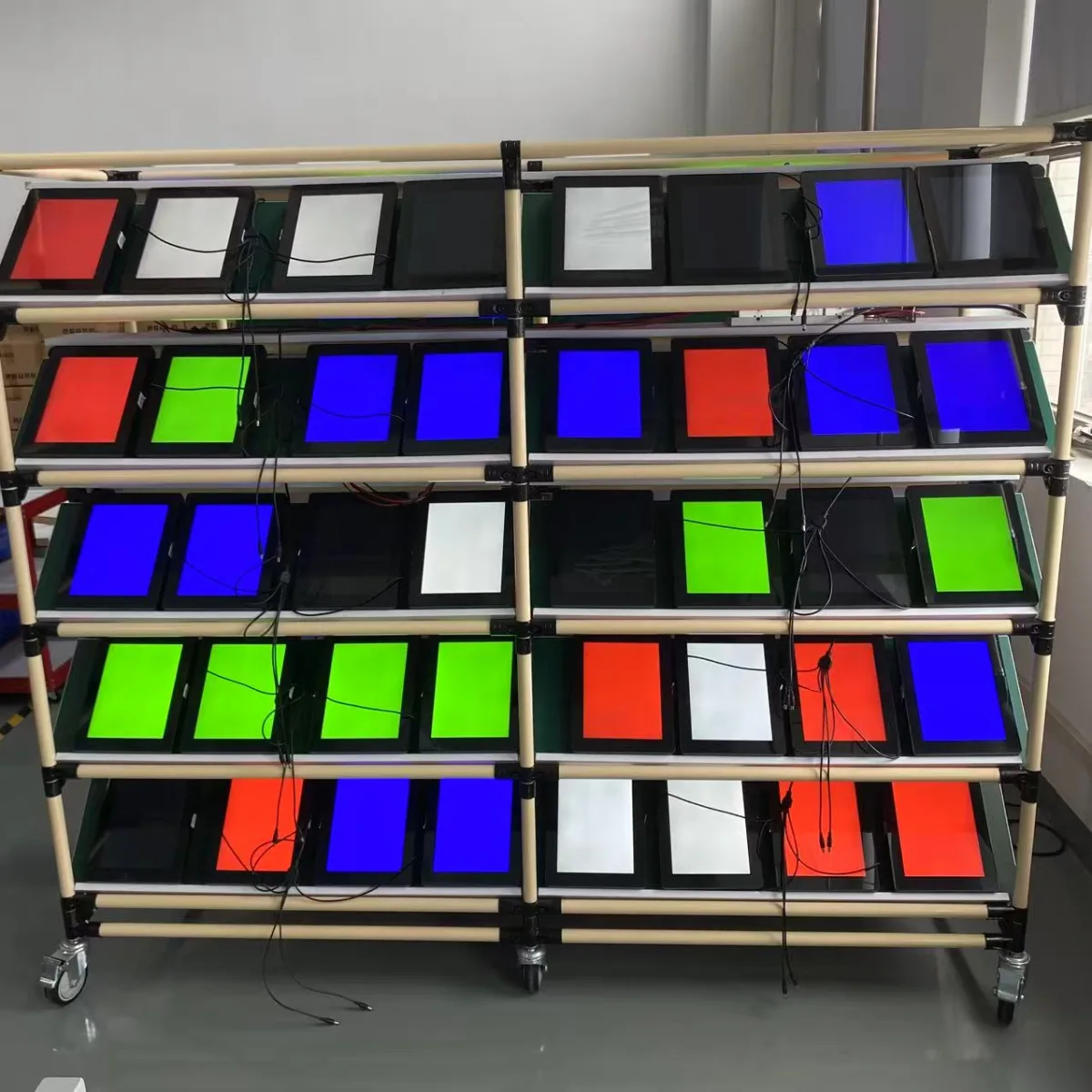 Rows of tablet screens running red/green/blue display and colour-uniformity tests — Wintouch QC